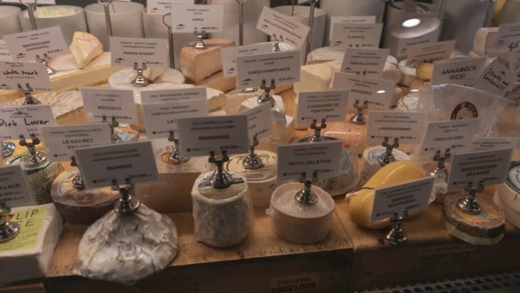 Étal de fromages artisanaux avec nombreuses étiquettes