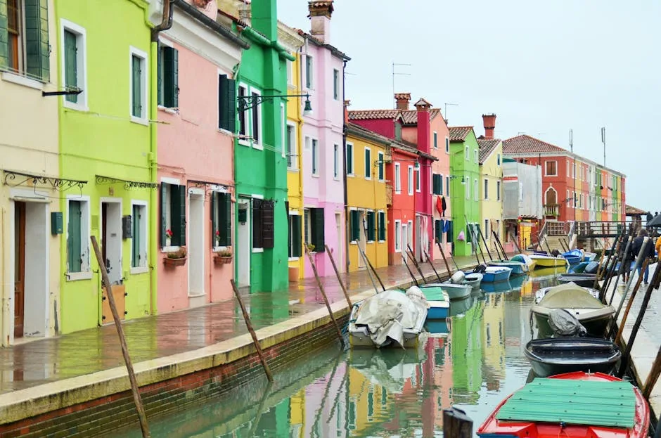 Façades pastels réfléchies dans l'eau d'un canal de Burano.