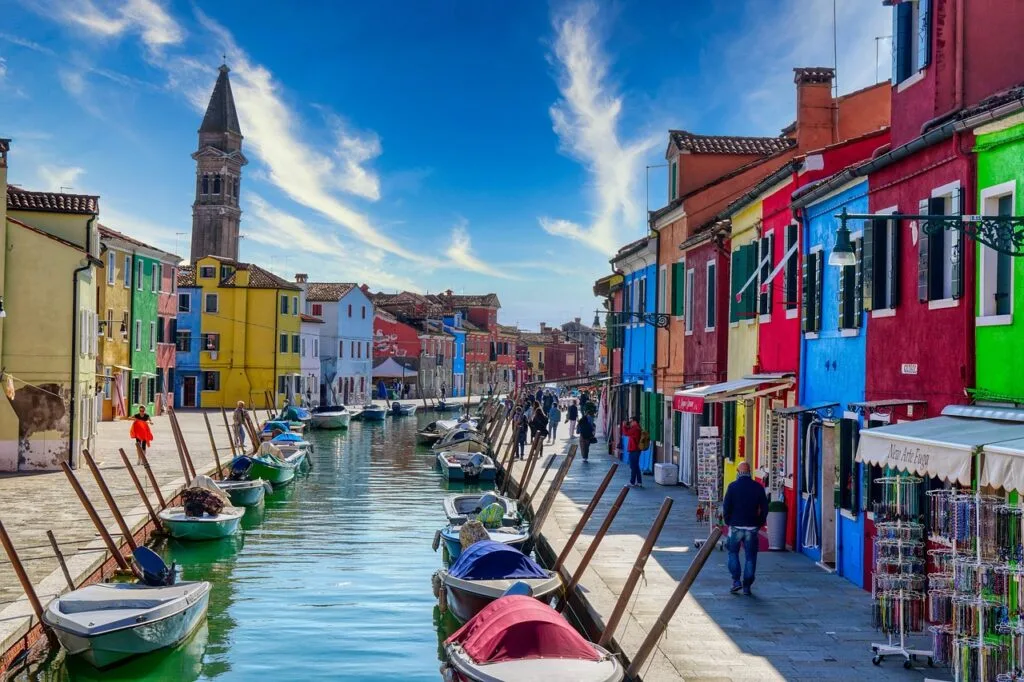 Canal animé bordé de maisons colorées et passants à Burano