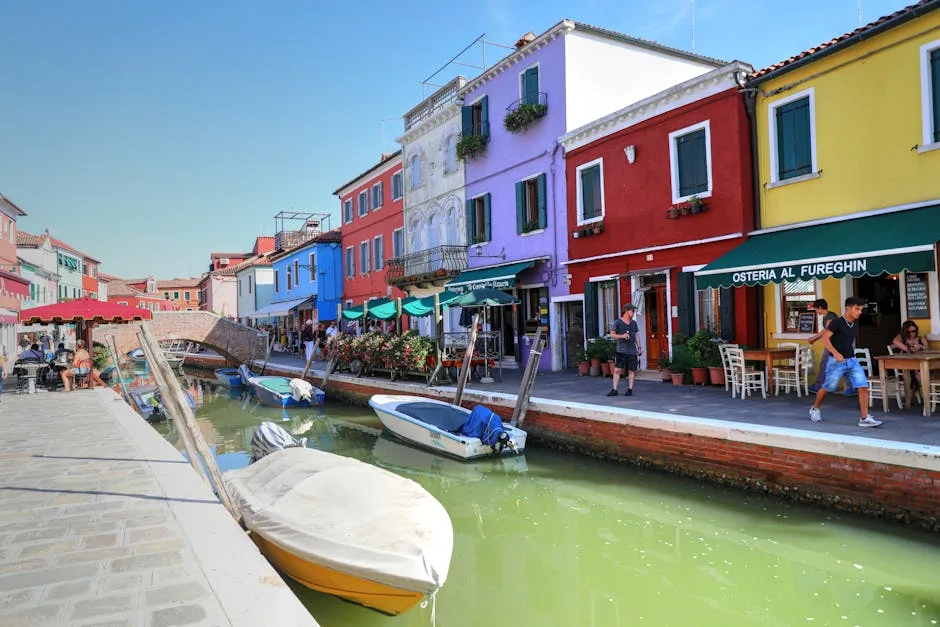 Kanal mit bunten Häusern und Restaurants auf Burano, Venedig