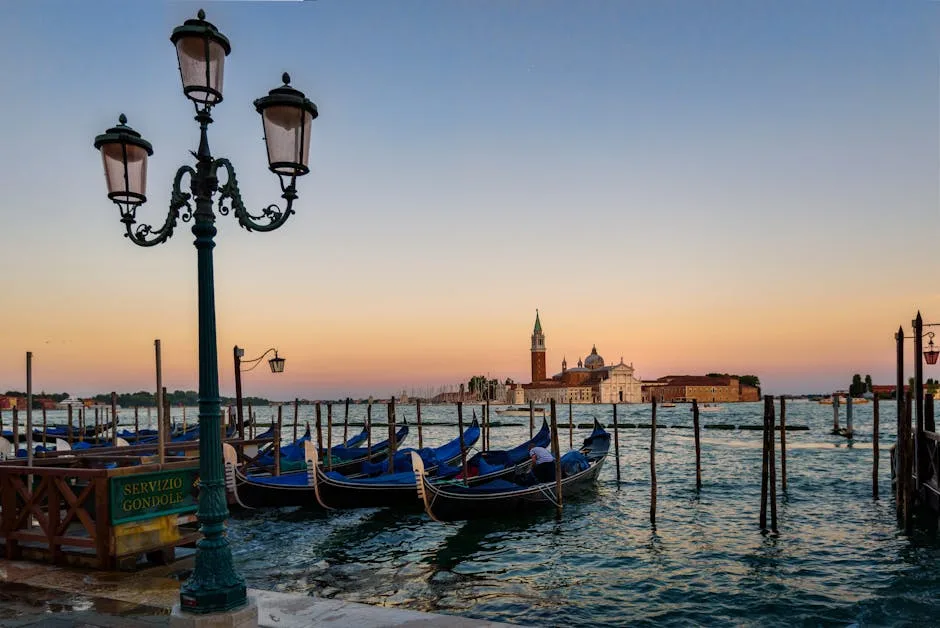 Gondoles alignées au bord de l'eau, vue sur l'île San Giorgio Maggiore à Venise