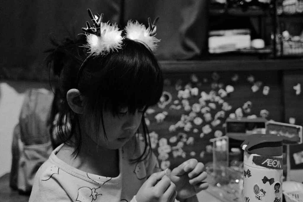 Fillette concentrée faisant un bricolage à l'intérieur, serre-tête à plumes