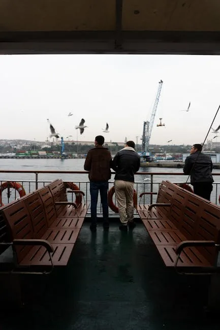 Trois hommes debout près de bancs sur le pont d'un ferry