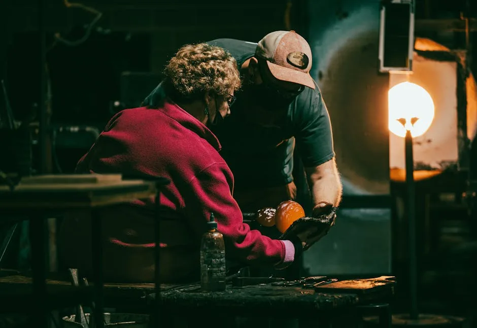 Artisan et visiteuse manipulant du verre en fusion dans un atelier de Murano
