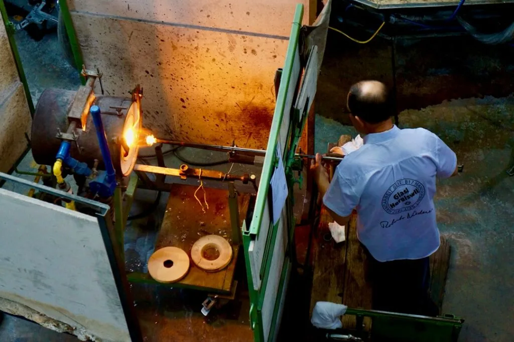 Souffleur de verre maniant une canne devant un four à Murano