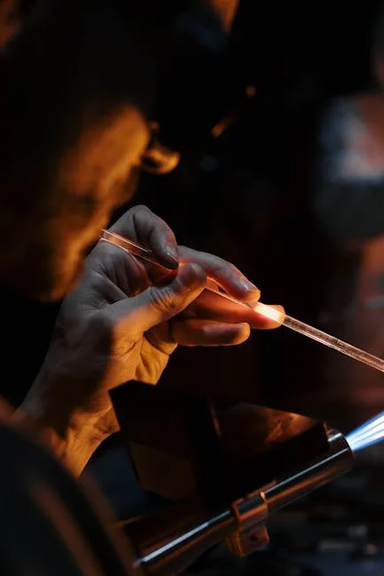 Souffleur de verre modelant une tige en fusion dans un atelier de Murano