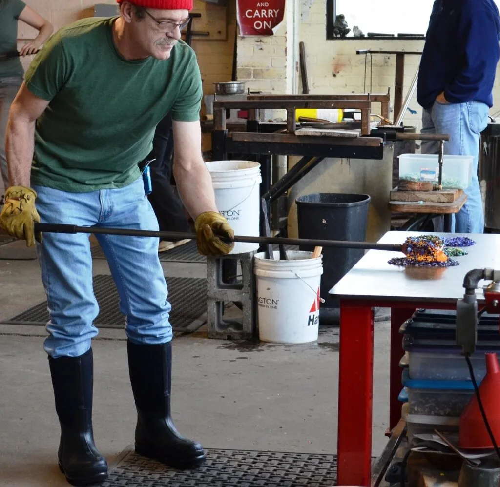 Artisan soufflant le verre dans un atelier de Murano, près de Venise
