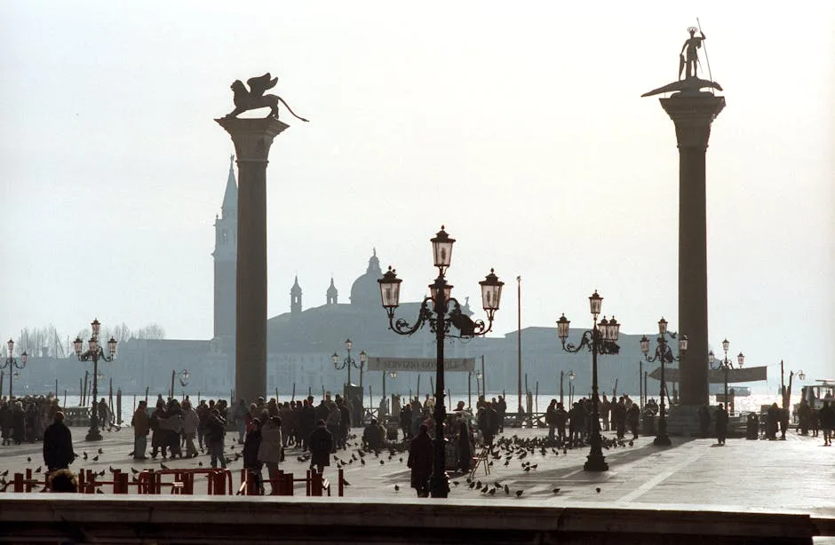 Menschen und Tauben zwischen den Säulen auf dem Markusplatz in Venedig
