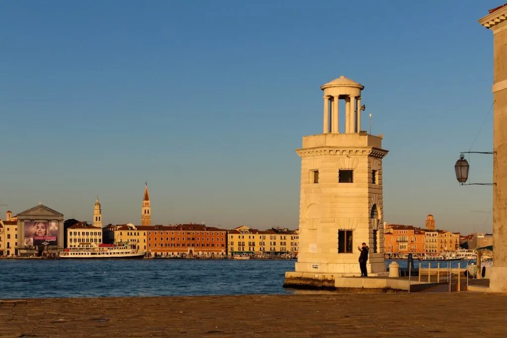 Un petit phare en pierre au bord du canal, vue sur Venise