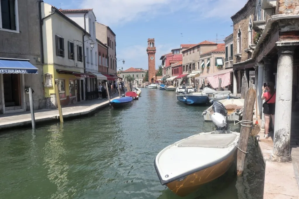 Schmaler Kanal mit angelegten Motorbooten und Uferläden in Venedig