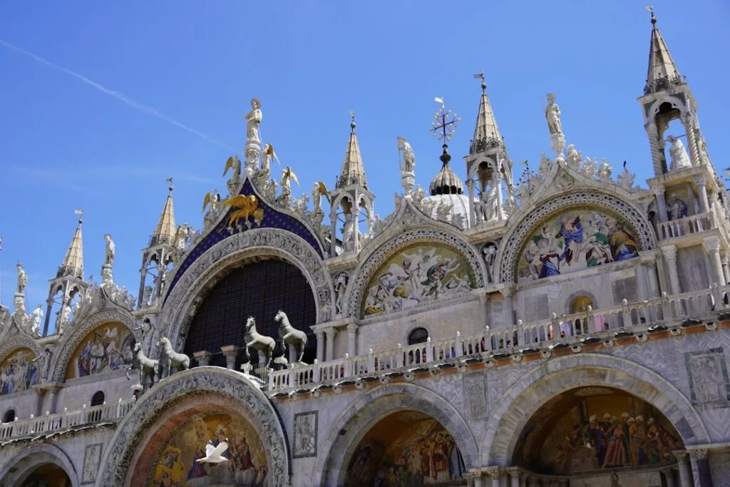 Fassade der Markusbasilika in Venedig mit vier Pferdestatuen und Mosaiken