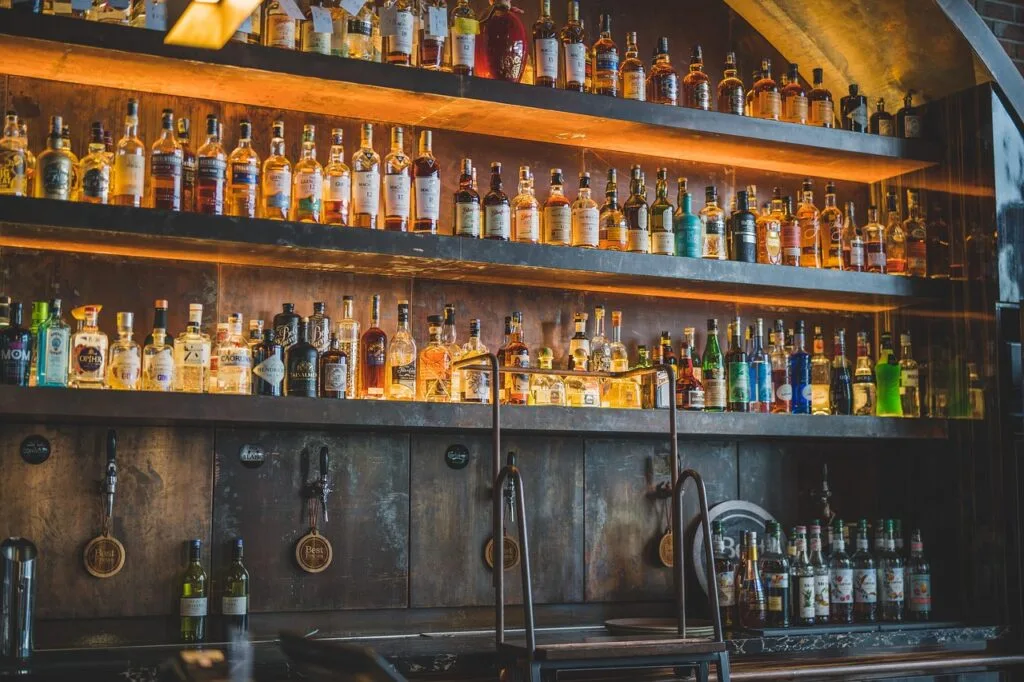 Étagères remplies de bouteilles derrière le comptoir d'un bacaro vénitien.