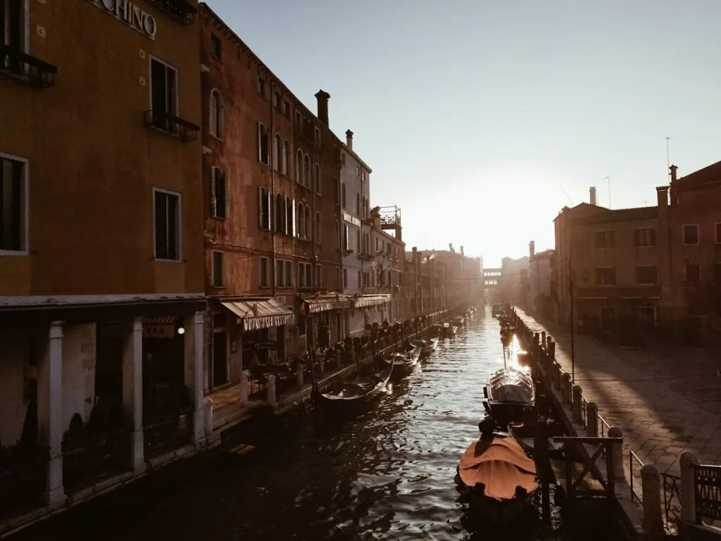 Gondoles amarrées le long d'un canal de Venise au coucher du soleil