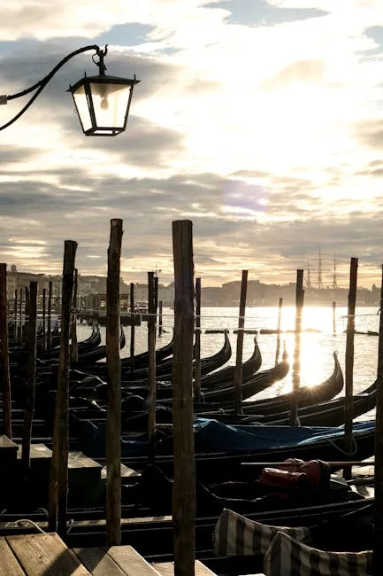 Gondoles alignées au lever du soleil près d'un lampadaire à Venise