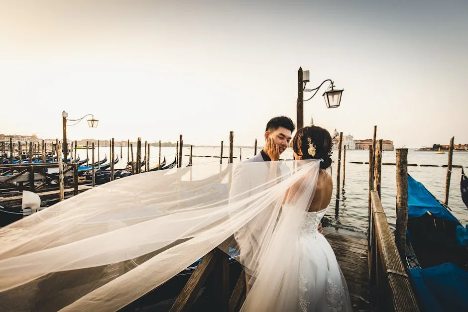 Couple de mariés sur un quai à Venise, voile flottant