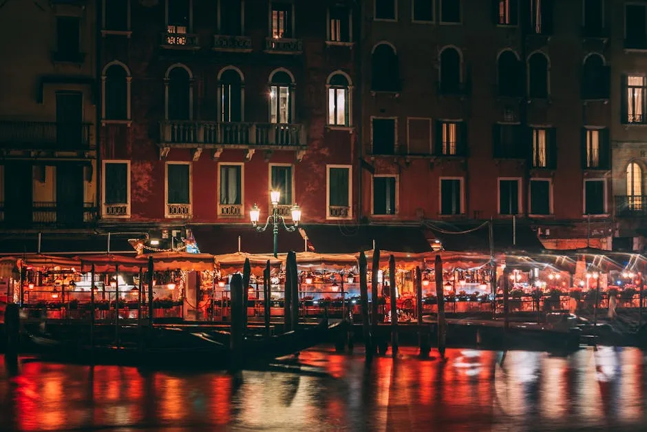 Terrasses de restaurants éclairées le long d'un canal à Venise la nuit