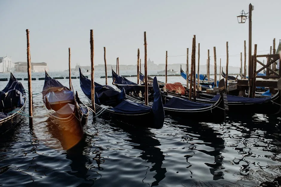 Rij gondels vastgebonden aan palen in het water van Venetië