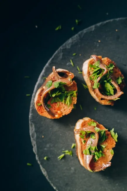 Trois cicchetti vénitiens garnis d'anchois et de persil sur ardoise