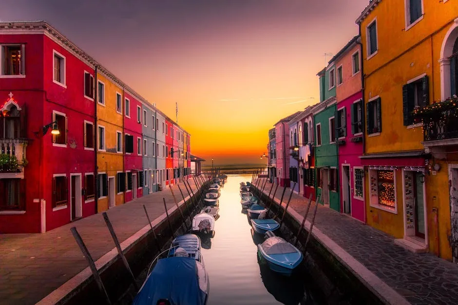 Maisons colorées de Burano au coucher du soleil, bateaux le long du canal