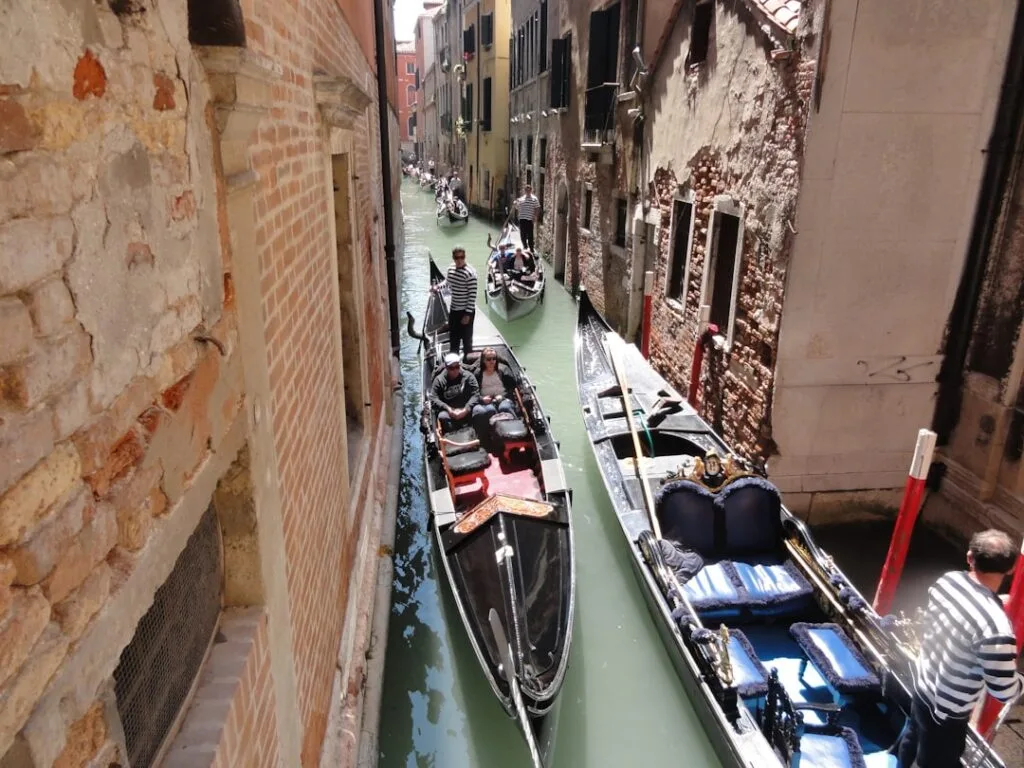 Gondoles serrées dans un canal étroit de Venise, gondoliers en marinière
