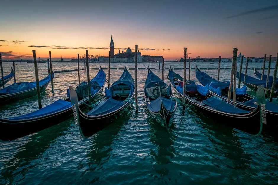 gondoles noires alignées au coucher de soleil face à Venise