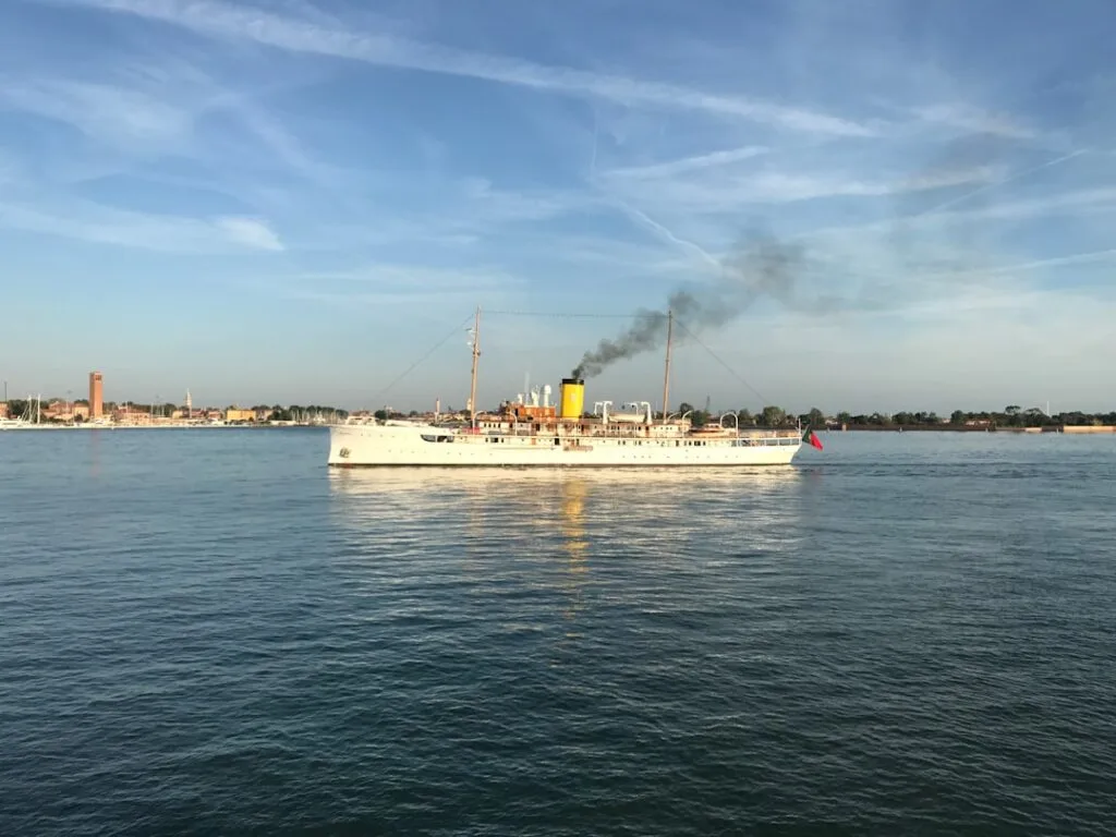 Dampfschiff mit schwarzem Rauch vor der Küste von Venedig