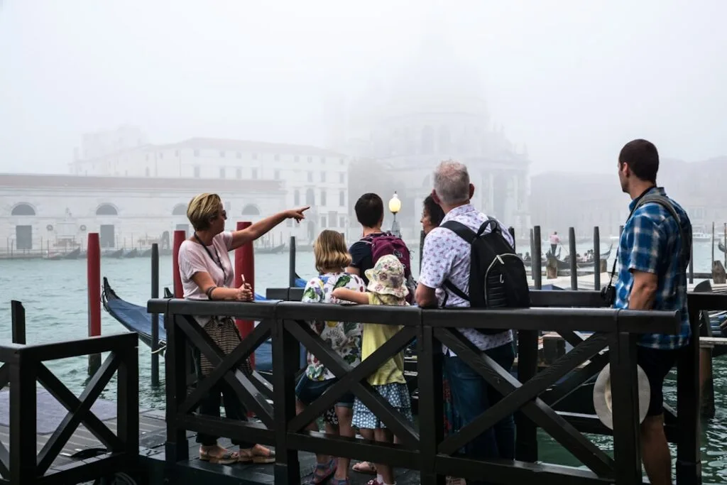 Groupe de touristes observant la lagune brumeuse et Venise lointaine