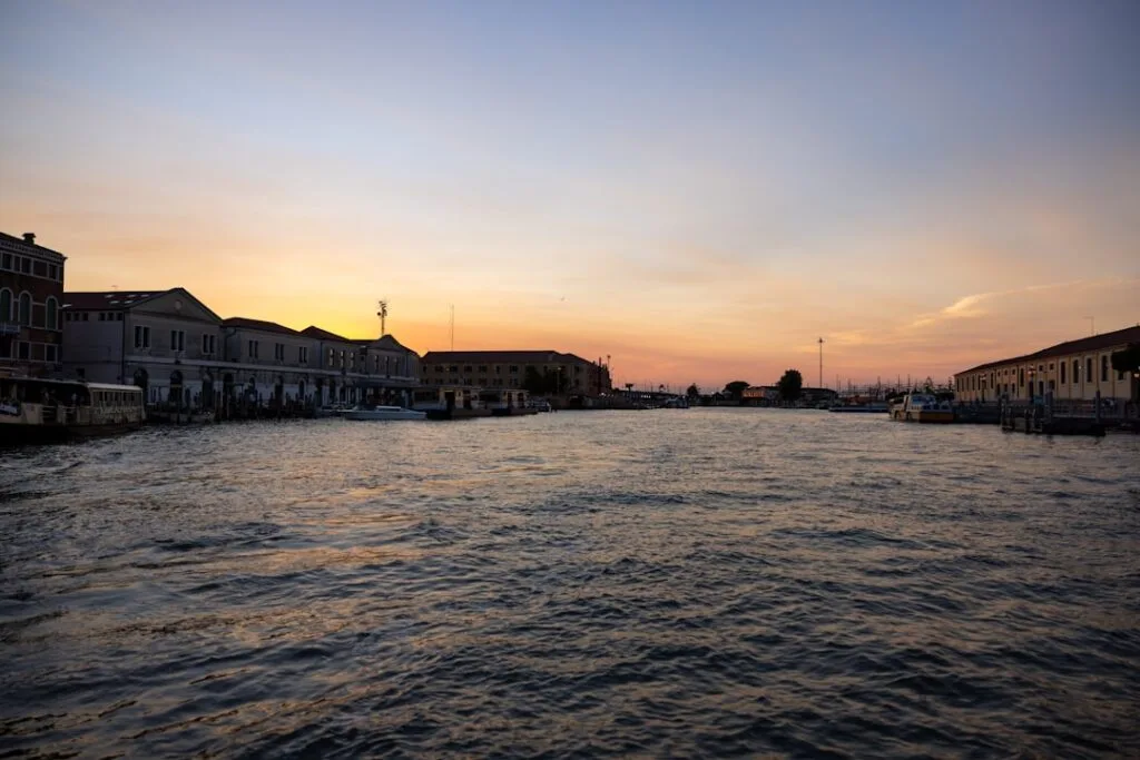 Le canal de Venise au coucher du soleil, eaux calmes et silhouettes