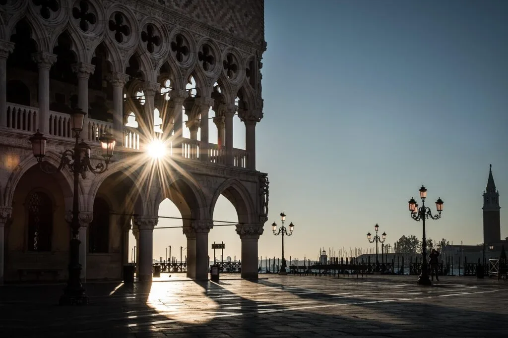 Lever de soleil filtrant sous les arches du Palais des Doges à Venise