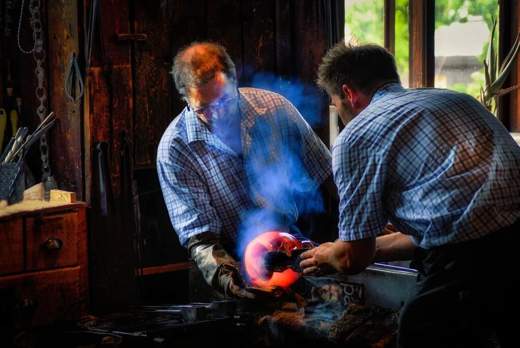 Artisans du verre à Murano façonnant une pièce en verre en fusion