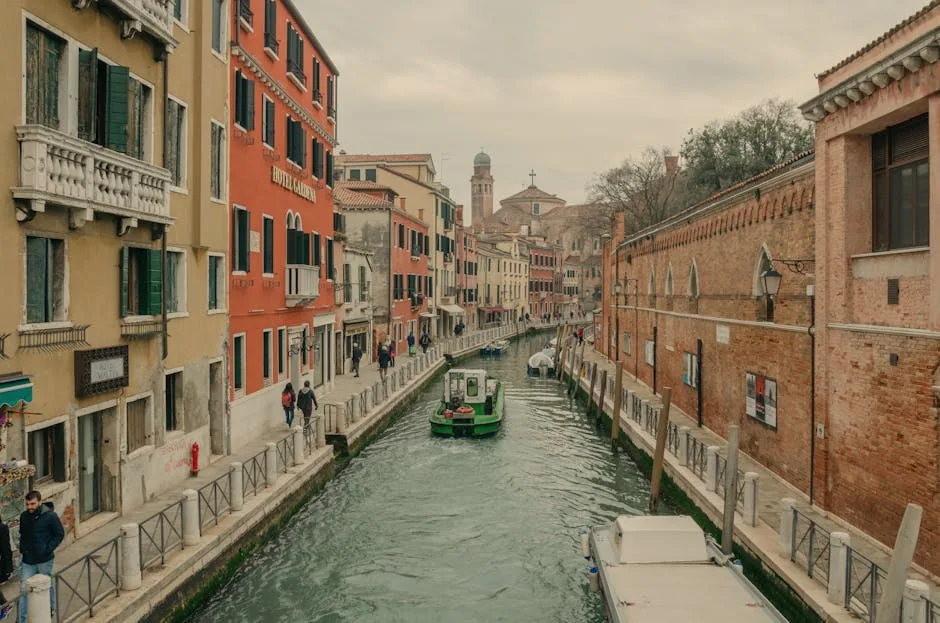 Canal étroit bordé d'immeubles colorés et d'un vaporetto à Venise