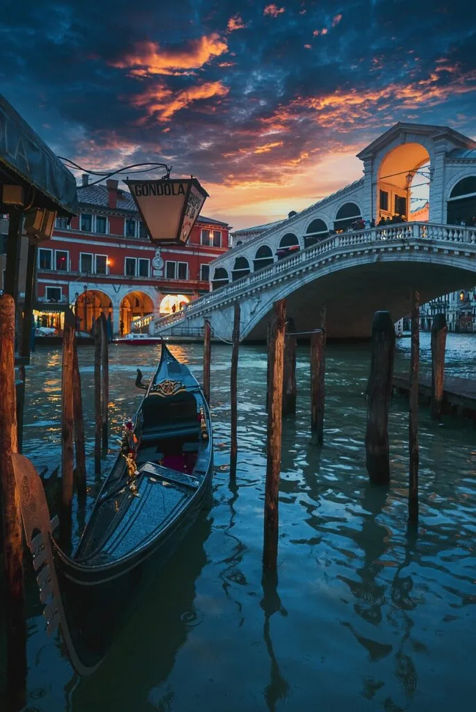 Gondole amarrée devant le pont du Rialto à Venise au coucher de soleil