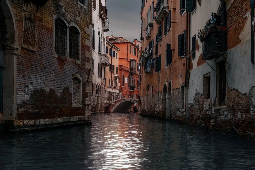 Canal étroit de Venise encadré de façades en brique et pont